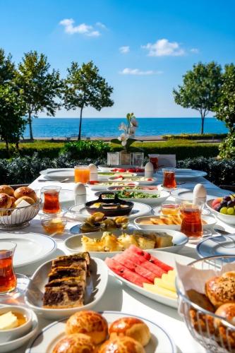 a table full of food with the ocean in the background at Kalyon Hotel Istanbul in Istanbul