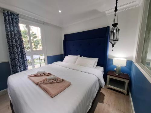 a bedroom with a large bed with a blue headboard at Seven Seas Code di Azur in Na Jomtien