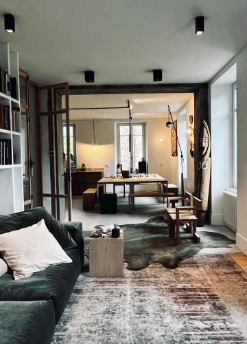 a living room with a couch and a table at MAISON BO TERRA - Chambres et table d'hôtes - Massif des Écrins in Valbonnais