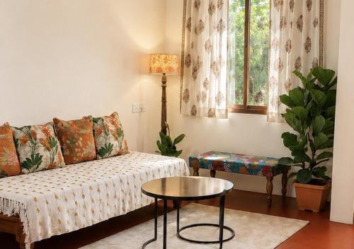 a living room with a couch and a table at Priyaman Retreat in Madikeri