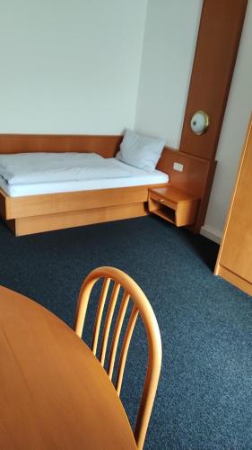 a room with a table and a bed and a chair at Ennstalerhof Hotel-Restaurant in Grossraming