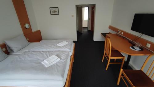 a room with two beds and a desk and a computer at Ennstalerhof Hotel-Restaurant in Grossraming
