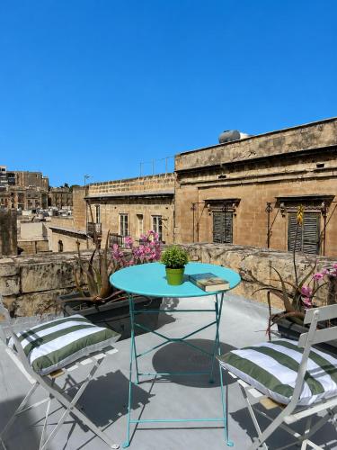 a table and chairs on a patio with an old building at Carmelita in Valletta