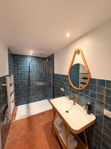 a bathroom with a sink and a shower with a mirror at Hôtel Le Neptune en Camargue in Saintes-Maries-de-la-Mer
