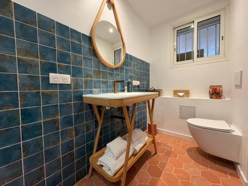 a bathroom with a sink and a mirror and a toilet at Hôtel Le Neptune en Camargue in Saintes-Maries-de-la-Mer