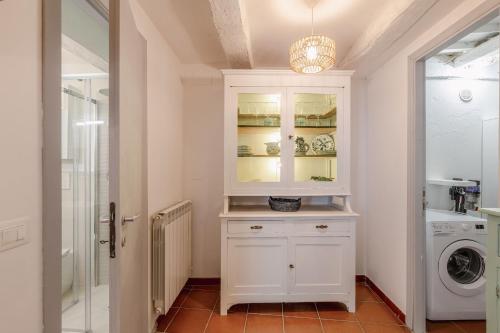 a laundry room with a white cabinet and a washing machine at Italian Experience-La Terrazza nel Borgo in Marsciano