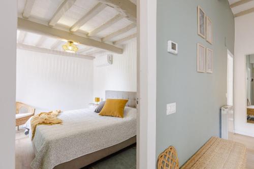 a white bedroom with a bed with yellow pillows at Italian Experience-La Terrazza nel Borgo in Marsciano