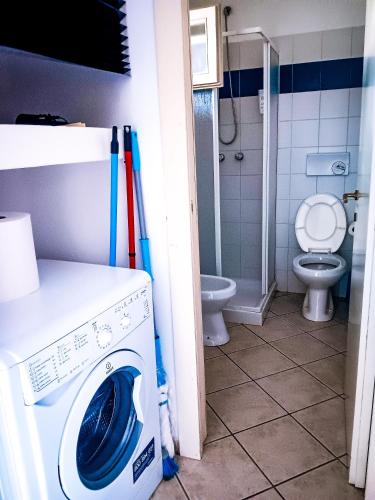 a washing machine in a bathroom with a toilet at Casa di Luga in Costa Paradiso