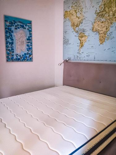 a bed in a room with a map on the wall at Casa di Luga in Costa Paradiso