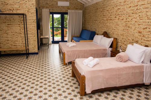 a hotel room with two beds and a blue chair at Fazenda Castanheira in Monte Verde