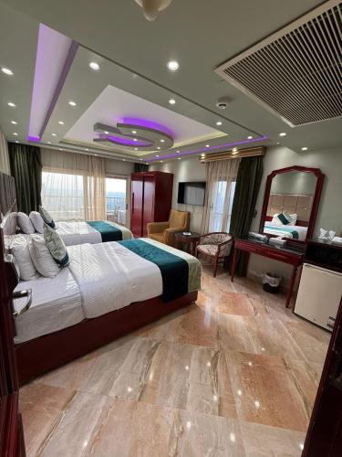 a bedroom with a large bed and a living room at Nile Royale Hotel in Cairo