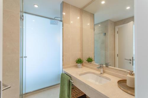 a bathroom with a sink and a glass shower at Villa Coco in Mogán