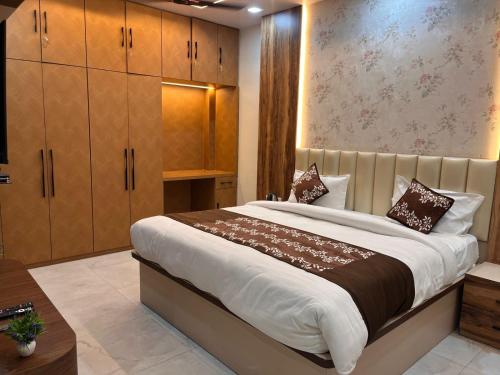 a bedroom with a large bed and wooden cabinets at MorningInn in Prayagraj