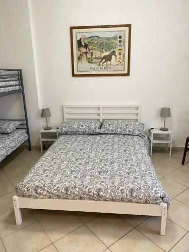 a bed in a bedroom with a picture on the wall at Renaio House Buti in Bientina