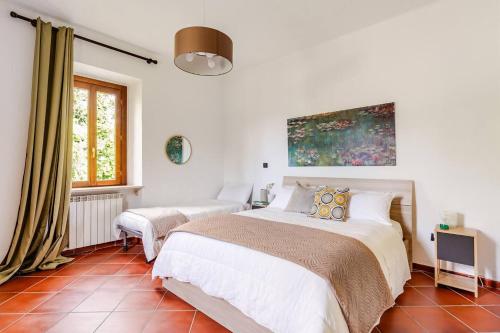 a white bedroom with a bed and a window at Fuga nel Parco Trebbia, vicino Grazzano/Bobbio in Rivergaro