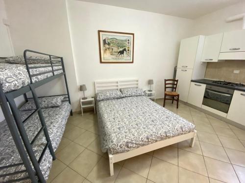a bedroom with two bunk beds and a kitchen at Renaio House Buti in Bientina