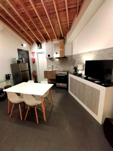 a kitchen with a white table and chairs in a room at Sons da Ribeira in Ribeira Grande