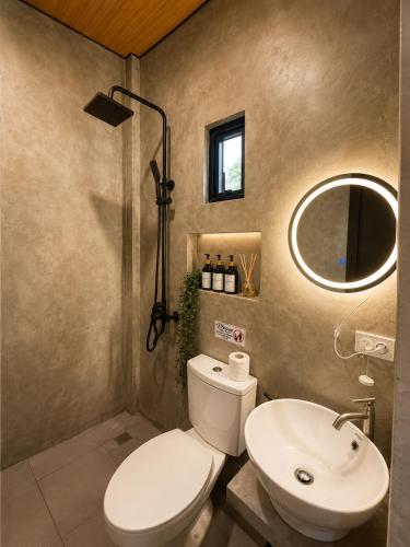a bathroom with a toilet and a sink and a mirror at Astra Tourist Inn near Airport with high speed free Wifi in Puerto Princesa City