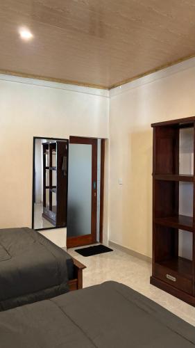 a bedroom with a bed and a dresser and a mirror at Villa Nacita in Bumbang