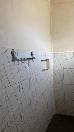 a bathroom with a white tiled wall with a towel rack at Villa Nacita in Bumbang
