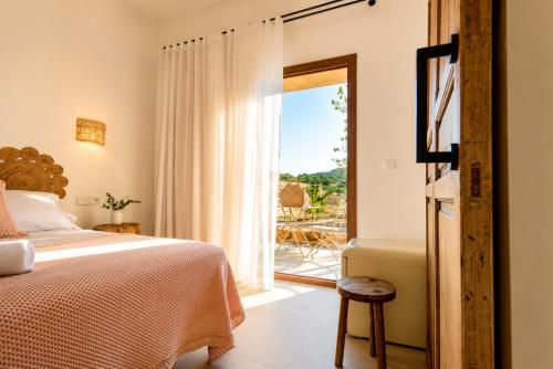 a bedroom with a bed and a door leading to a patio at Ribazos de la Sierra in Carmona