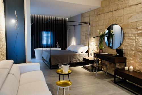 a living room with a bed and a bath tub at Nicanto Rooms in Taranto