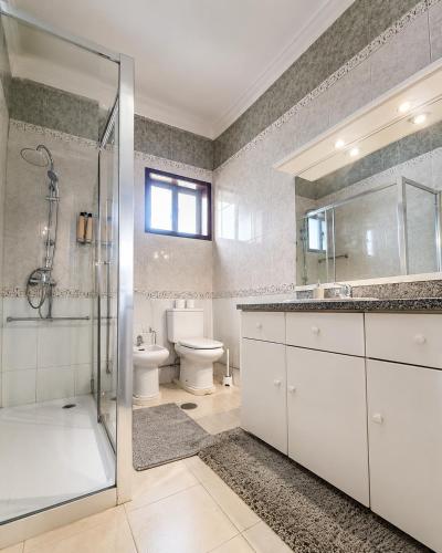 a bathroom with a shower and a sink and a toilet at Casa Quixote Matosinhos in São Mamede de Infesta