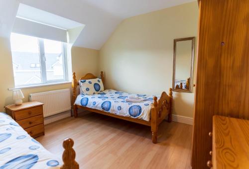 a small bedroom with a bed and a mirror at Montbretia - Ballinskelligs in Dungeagan
