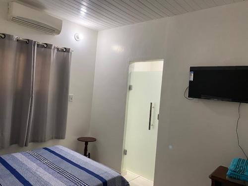 a bedroom with a bed and a television on the wall at Hotel Maria in Marabá