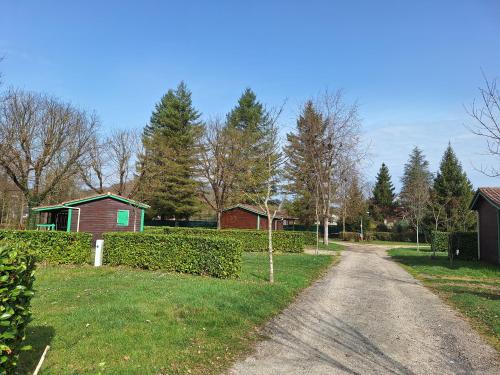 a dirt road in a yard with houses and trees at Camping Onlycamp Les Bords de Lyonne in Saint-Jean-en-Royans