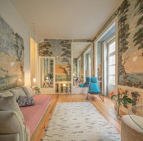 a living room with a couch and blue chairs at Antiga Casa Pessoa in Lisbon