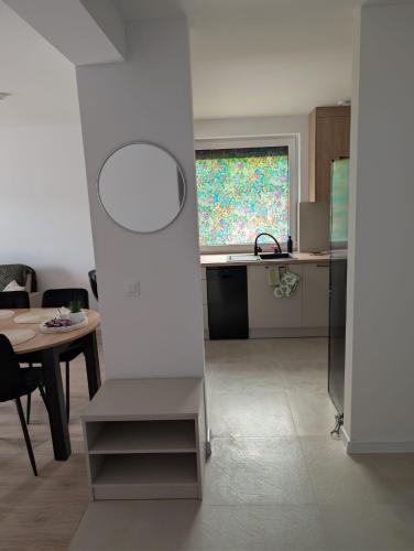 a kitchen and dining room with a table and a window at Apartament Las in Żagań