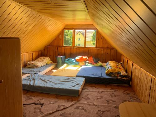 a room with two beds in a wooden house at Chata u řeky Svatavy in Josefov