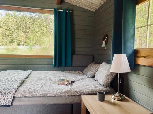 a bedroom with a bed with a desk and a window at Domki w Lesie in Silnowo