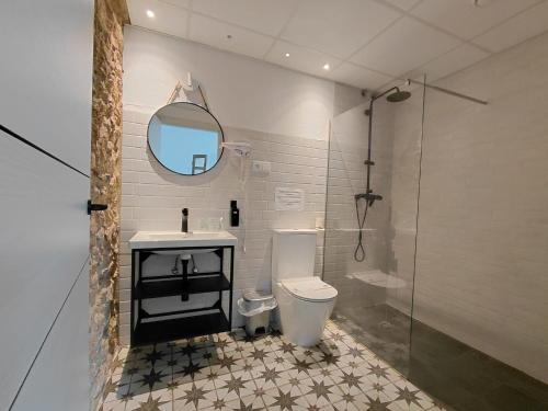 a bathroom with a toilet and a sink and a mirror at Hotel Rural Casa Cuartel in San Vicente de Alcántara