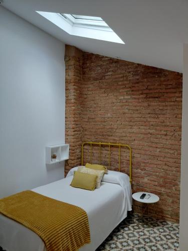 a bedroom with a bed and a brick wall at Hotel Rural Casa Cuartel in San Vicente de Alcántara