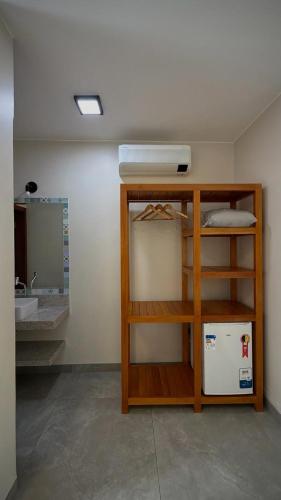 a room with a sink and a shelf with a refrigerator at Pousada Mãe Natureza in Pirenópolis
