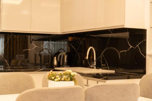 a kitchen with white cabinets and a table with chairs at Villa Rafail in Ksamil