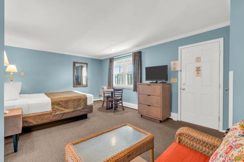 a hotel room with a bedroom with a bed and a desk at Surfside Motel in Point Pleasant Beach