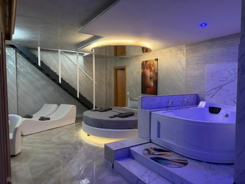 a bathroom with a purple tub and a bed at B&B Luxury Room e Spa in Apricena