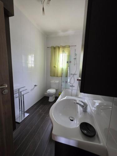 a white bathroom with a sink and a toilet at Vendome in Paceville
