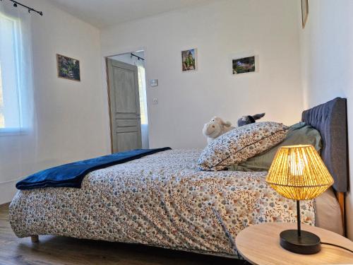 a bedroom with a bed and a table with a lamp at Le Clos des Elfes - suite climatisée in La Roque-Gageac