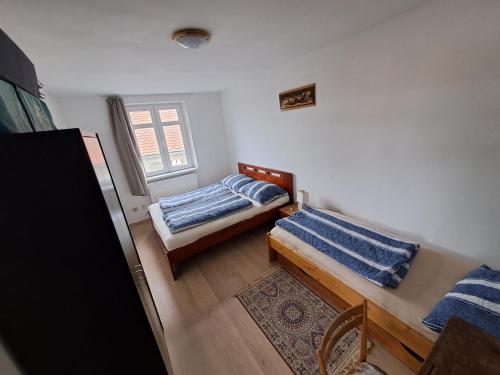 a small room with two beds and a table at Vila Galant in Konice