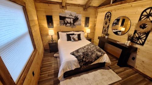 a bedroom with a bed in a log cabin at Micham's Clark Fork River Retreat - River Front, Mountain View, Fire Pit - Cabin 1 in Superior