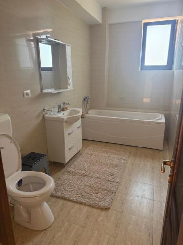 a bathroom with a toilet and a tub and a sink at Eli house in Târgu Neamț