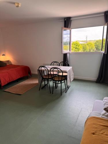 a room with a table and chairs and a bed at Studio les Écuries de la forêt 2 in Le Buisson Genois