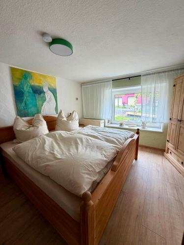 a bedroom with a large wooden bed with white sheets at EifelFein in Niederstadtfeld