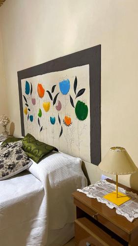 a bedroom with a bed with a painting on the wall at By Lela in Tinogasta