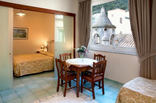 a room with a table and chairs and a window at Hotel L'Antico Convitto in Amalfi