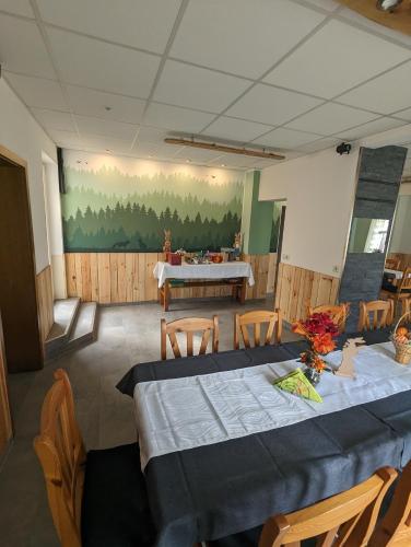 a dining room with a table and chairs and a painting at Gästehaus Stein im Thüringer Wald in Rottenbach